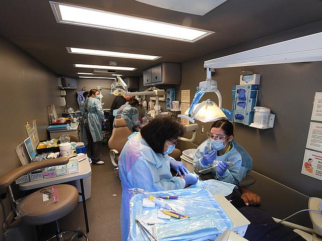 Three dental chairs keep busy with patients inside a specially equipped recreational vehicle operated by the Tzu Chi Medical Foundation during a recent visit to Stockton. (Photo: Joe Goldeen) Caption: Three dental chairs keep busy with patients inside a specially equipped recreational vehicle operated by the Tzu Chi Me