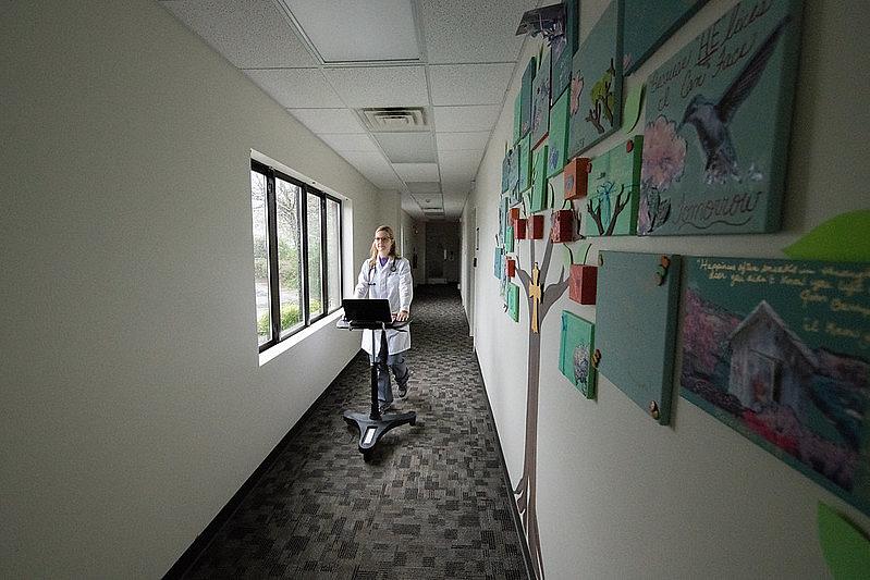 Physician walks down hallway