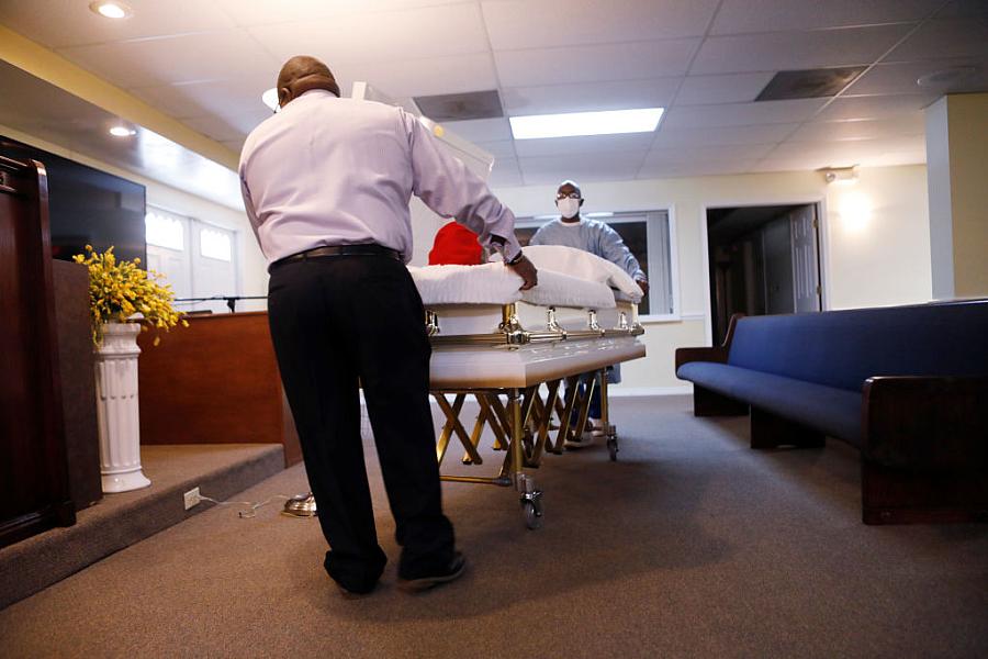 A mortician assistant and embalmer prepare a funeral service for a man who died in August of COVID-19 at Ray Williams Funeral Ho