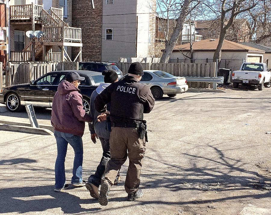 Chicago police officers take a heroin buyer into custody on West Flournoy Street in Chicago. 