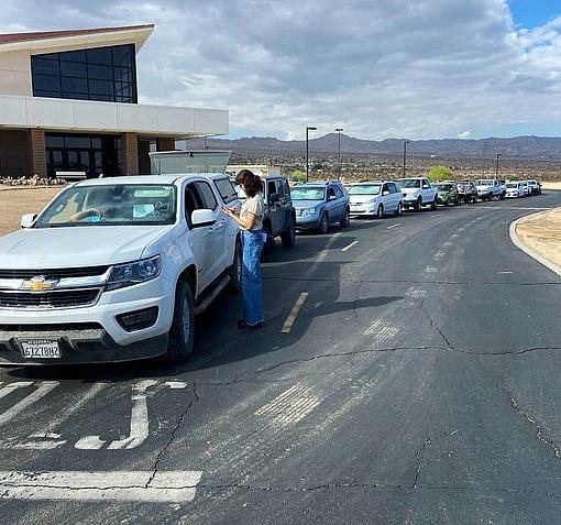 A line of more than 30 cars await a food distribution event to begin at Copper Mountain College in Joshua Tree on Aug. 2, 2022. For many in the line, record inflation and limited access to fresh produce has forced them to seek help. A line of more than 30 cars await a food distribution event to begin at Copper Mountain College in Joshua Tree on Aug. 2, 2022.