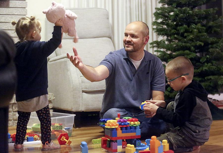 Dustin Wallis, a nonsmoker who has stage 4 lung cancer, plays with his children in Cottonwood Heights, Utah.
