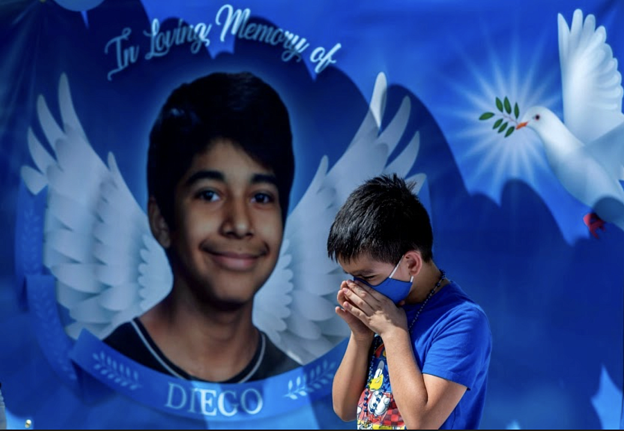 Eric Henry, a 9-year-old Moreno Valley boy, prays in front of a memorial for Diego Stolz
