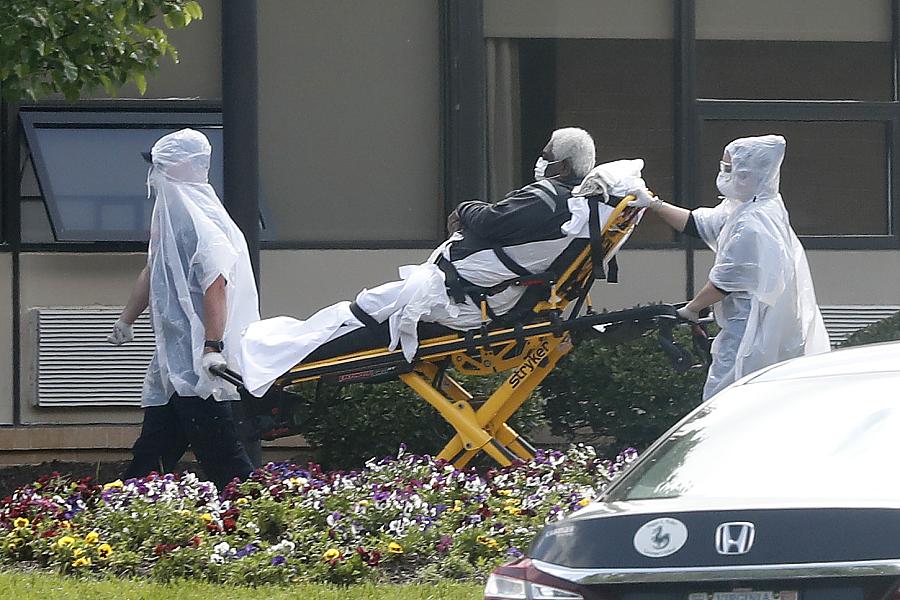 A nursing home resident is wheeled on a stretcher from an ambulance into the Canterbury Rehabilitation and Healthcare Center