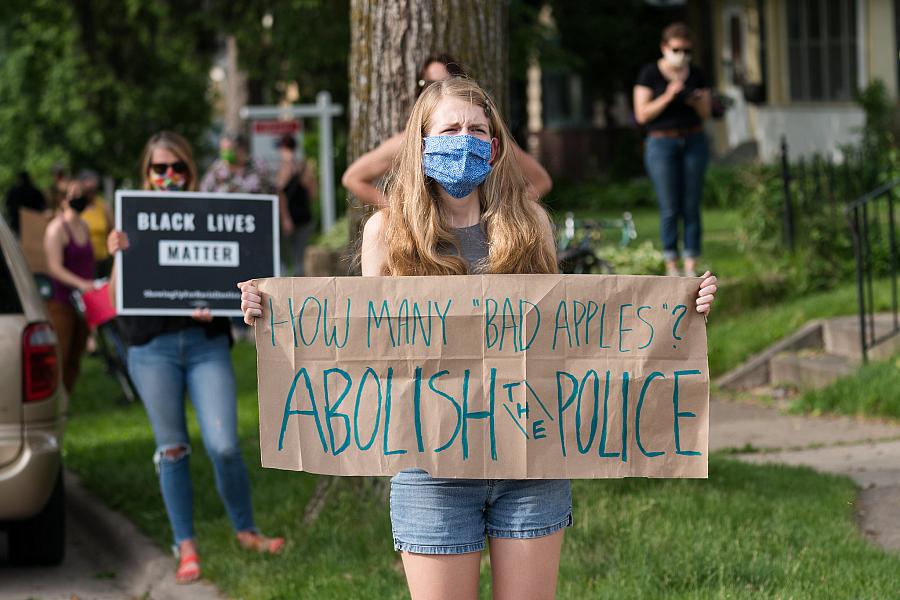 A protestor holds a sign along 38th Street in Minneapolis.