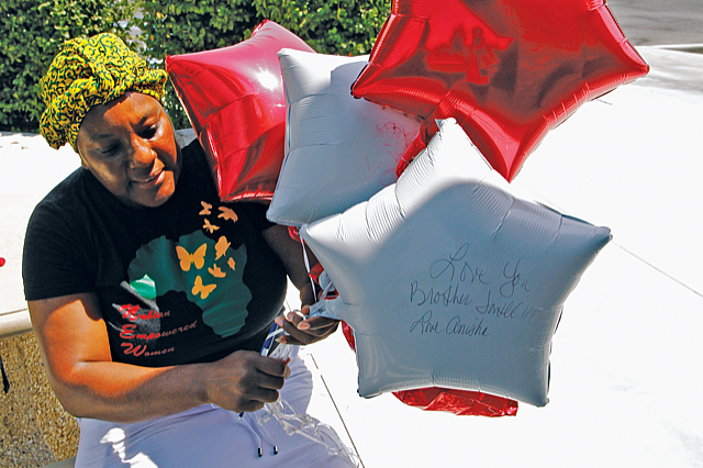 Anyka Harris holds balloons with messages from her and her family for her son Jontell Reedom, who suffered from schiz