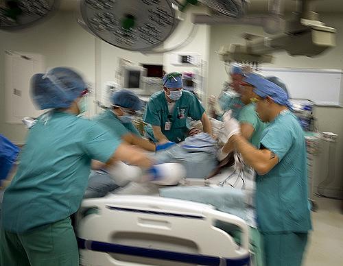 Medical workers transfer patient to surgical table . 