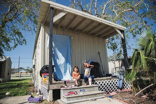 Laila Garcia, 4, left, and her sister, Zoey Garcia, 5, sit on the front porch of their apartment in Bloomington in Sept. 2017. 