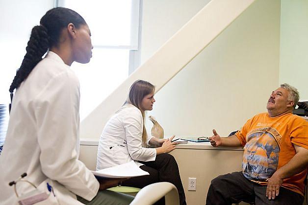Lillian Burnett (left) and Kimberly Gutowski, Cuban medical students in training at Highland Hospital, go over a checklist in Spanish with patient Juan Topete. Photo: Jason Henry, Special To The Chronicle
