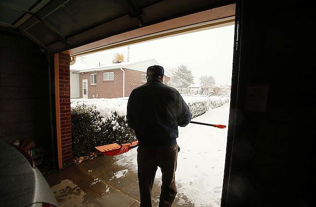 Roger Thompson, 99, gets ready to shovel the sidewalk at his home in Salt Lake City, Friday, Dec. 3, 2013 