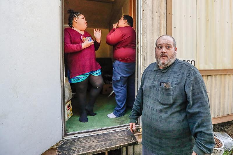 Brandon Hughes stands outside his family's trailer with his two children Vivianna Hughes, 9, and Brandon Hughes, 11.