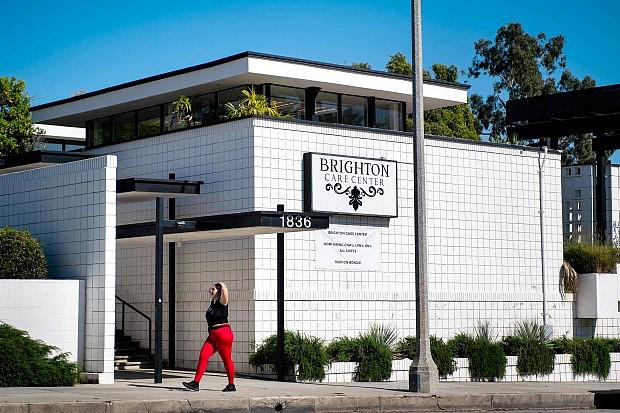 A woman passes Brighton Care Center in Pasadena on Wednesday, April 22, 2020 during the coronavirus pandemic. The skilled nursing facility has a COVID-19 outbreak according to the California Department of Public Health. (Photo by Sarah Reingewirtz, Pasadena Star-News/SCNG)