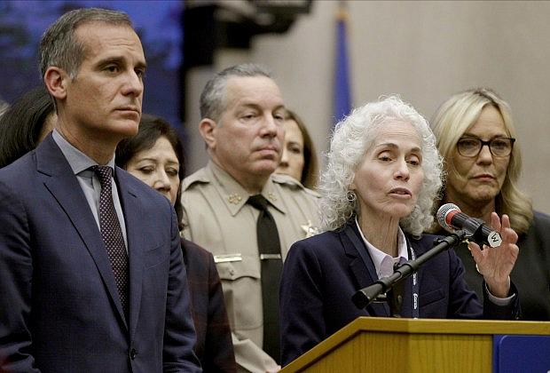 Los Angeles County Public Health Director Barbara Ferrer, at podium, speaks at a news conference with Los Angeles Mayor Eric Garcetti, left, in Los Angeles. (AP Photo/Damian Dovarganes,File)