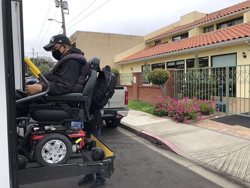 Kojo Nsoah boards a bus to his adult day health care facility down the coast in Half Moon Bay. It's one of the many things covered by his health plan. Angela Johnston