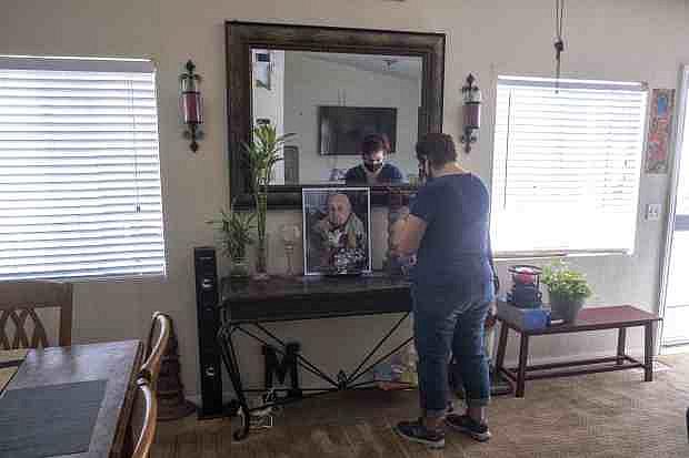 Marisela Munoz looks at a photo of her aunt, Evangelina C. Martinez, who raised her since birth, at her home in Canyon Country, Friday Aug. 28, 2020. Martinez, a resident of Astoria Nursing and Rehabilitation Center in Sylmar, died after becoming ill with COVID-19 at the age of 93. (Photo by Hans Gutknecht, Los Angeles Daily News/SCNG)