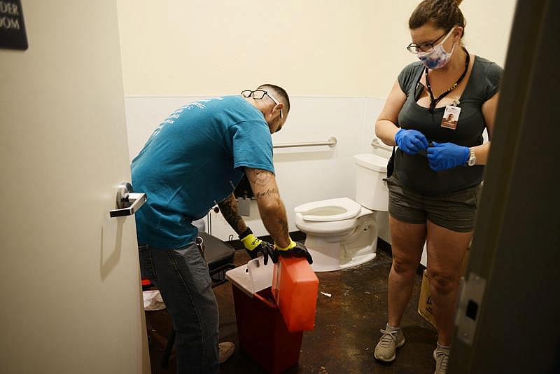 Shawn Horn recoge y elimina de forma segura las jeringuillas usadas en Building Bridges, un centro de recursos para personas sin hogar en Ukiah, el 15 de julio de 2021. MCAVHN opera el único intercambio de jeringas en el Condado de Mendocino. Shawn Horn safely collects and disposes of used syringes at Building Bridges, a homeless resources center in Ukiah, on July 15, 2021. MCAVHN operates the only syringe exchange in Mendocino County. (Photo by Dana Ullman/ The Mendocino Voice)