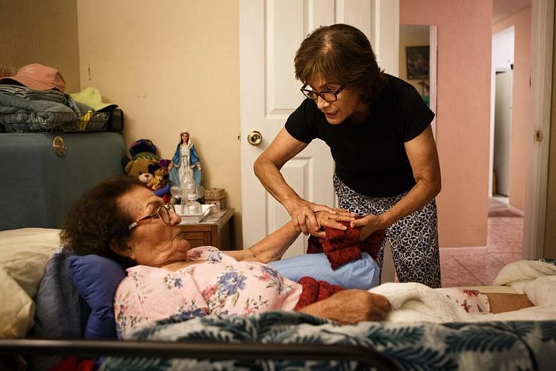 Ana Nicho Luu helps her mother, Maura, settle in her bed at night in their Santa Clara home in August 2021. (Dai Sugano/Bay Area News Group) 