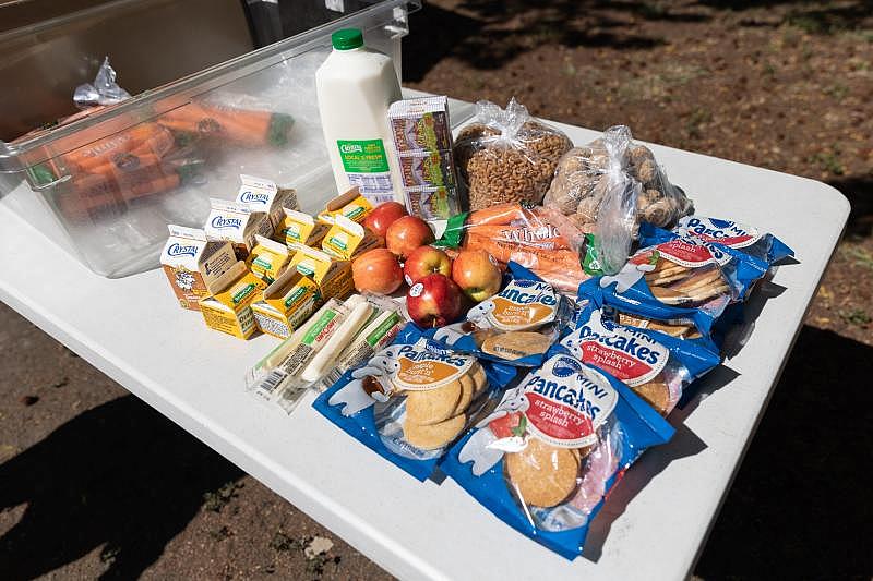 An assortment of food, including milk, pancakes, apples, carrots, pasta, raisins and cheese are ready for distribution at Los Robles Ronald McNair Academy in East Palo Alto on April 28. Photo by Magali Gauthier. An assortment of food, including milk, pancakes, apples, carrots, pasta, raisins and cheese are ready for distribution at Los Robles Ronald McNair Academy in East Palo Alto on April 28. Photo by Magali Gauthier.