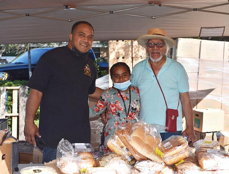 From left, Rev. Saulisi Kanongata'a, daughter Moala and family member Senita Uhilamoelangi are shown at the pop-up food distribution site they volunteer at in the parking lot of the St. Andrews United Methodist Church in Palo Alto, where Kanongata'a is pastor. Photo by Kate Bradshaw.