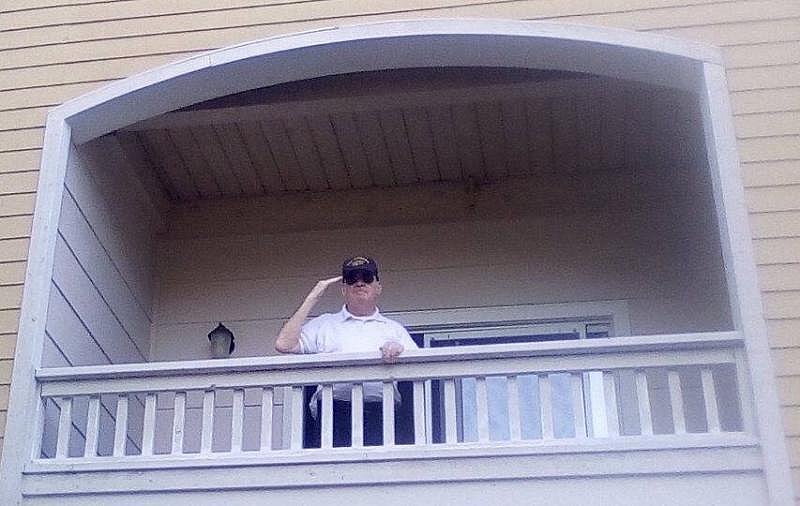 Once-homeless Navy veteran Robin Roberts, 78, salutes on the balcony of his one-bedroom apartment in San Jose. HomeFirst Services of Santa Clara County helped him secure housing. (Photo courtesy of Robin Roberts)