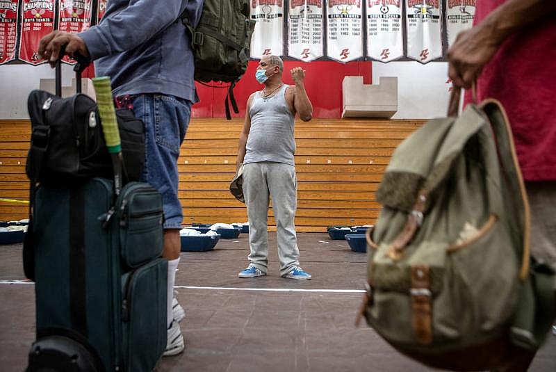 Johnny Alvarez, 47, center, motions to his mother upon checking into the emergency overnight shelter run by the Coachella Valley Rescue Mission inside a portion of the Palm Springs High School Gymnasium on Saturday , June 27, 2020. Taya Gray, Taya Gray