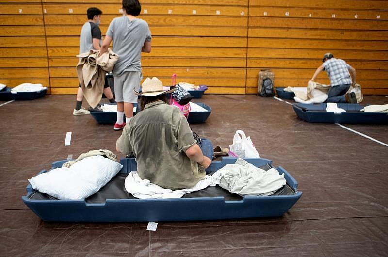 Janos Szilagyi, 39, center sits on his mattress inside the emergency overnight shelter run by the Coachella Valley Rescue Mission inside a portion of the Palm Springs High School Gymnasium on Saturday , June 27, 2020. Taya Gray, Taya Gray