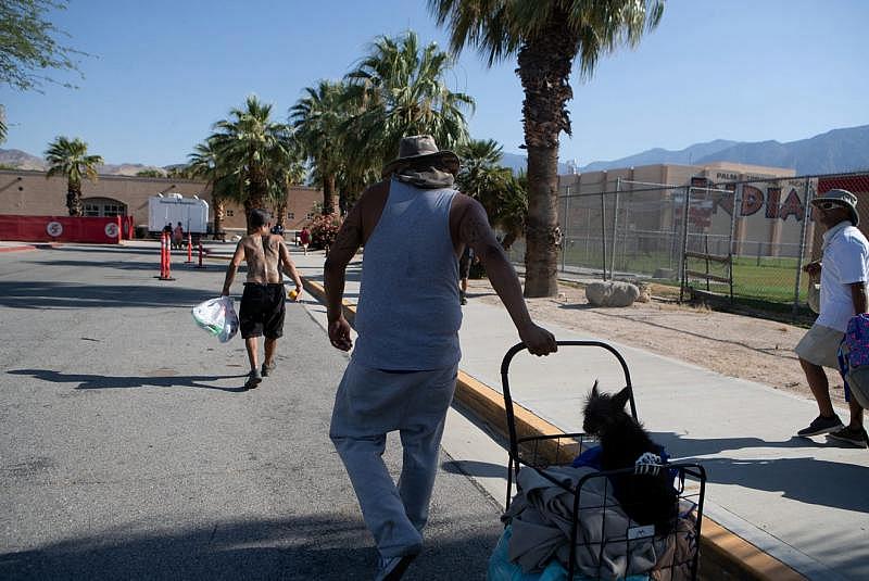 Johnny Alvarez, 47, center, walks toward the emergency overnight shelter run by the Coachella Valley Rescue Mission inside a portion of the Palm Springs High School Gymnasium on Saturday , June 27, 2020. Taya Gray, Taya Gray