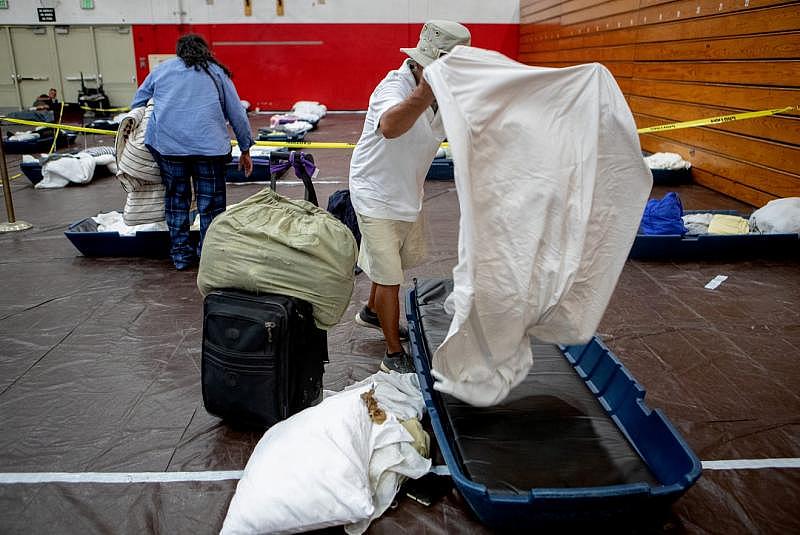 People place clean sheets on their mattress inside the emergency overnight shelter run by the Coachella Valley Rescue Mission inside a portion of the Palm Springs High School Gymnasium on Saturday , June 27, 2020. Taya Gray, Taya Gray