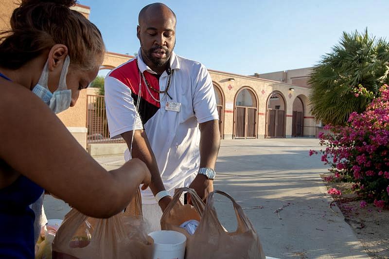 Coachella Valley Rescue Mission employee Charles Dangerfield the third, right, checks in a guest to the emergency overnight shelter run by the Coachella Valley Rescue Mission inside a portion of the Palm Springs High School Gymnasium on Saturday , June 27, 2020. Taya Gray, Taya Gray
