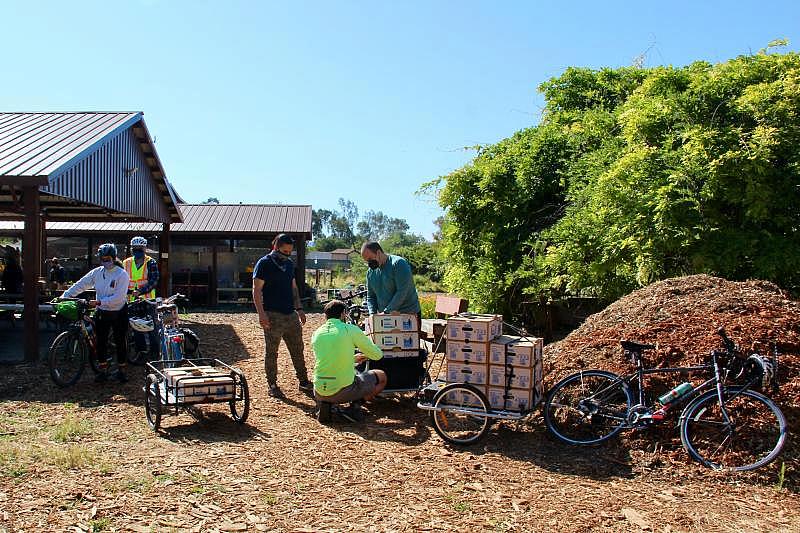 Volunteers load a bicycle trailer with food boxes to deliver to households in east San Jose on May 1, 2021. Courtesy Silicon Valley Bicycle Coalition. Volunteers load a bicycle trailer with food boxes to deliver to households in east San Jose on May 1, 2021. Courtesy Silicon Valley Bicycle Coalition.
