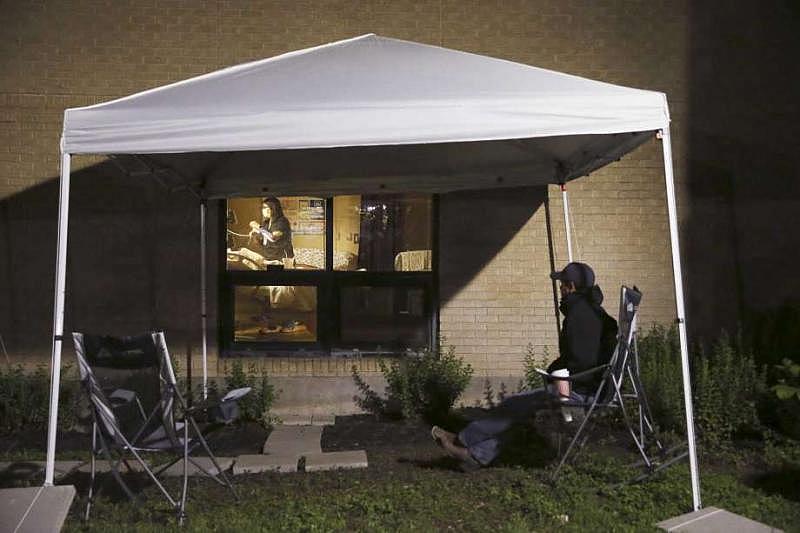 Before dawn, a nurse checked to see how Kayla’s labor had progressed. Alex watched intently from outside the window. (Jerry Lara | Express-News)