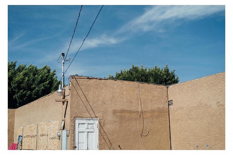 A stray wire dangles from the roof of a Mid-City apartment building cited in 2019 as "substandard." (AL KAMALIZAD / LAIST)