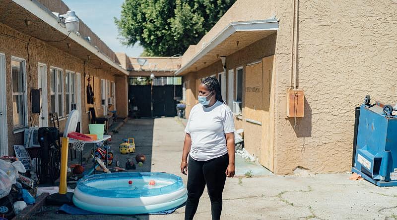 Kim Moore stands in a courtyard of the unpermitted apartment complex where she lives in L.A.’s Mid-City neighborhood. (AL KAMALIZAD/LAIST)