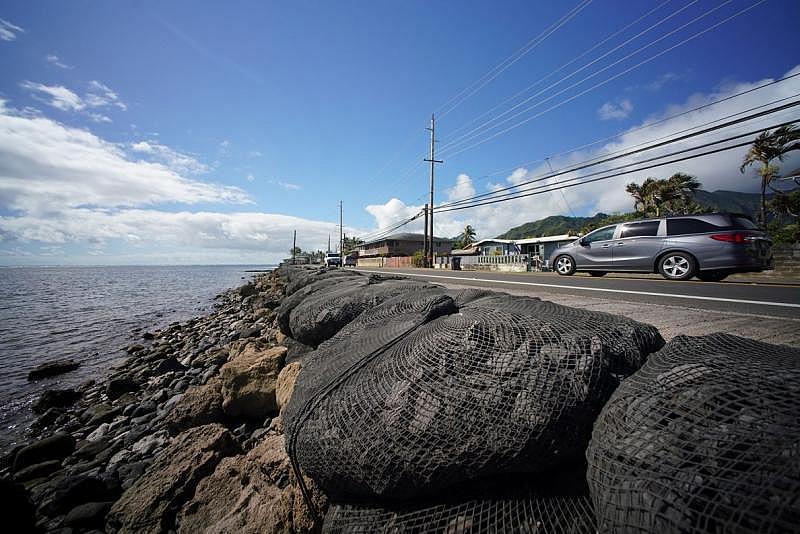 Large netted bags containing rocks along Kamehameha Highway in Hauula protect the highway from rising tides. 