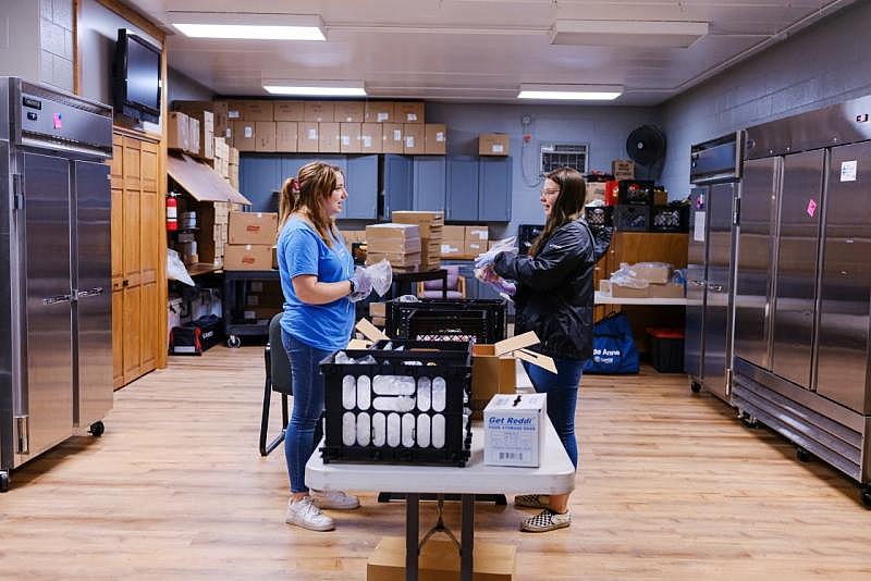 Terri Martin, left, and Shannon Bundridge pack the day's meals at the Adair County Family YMCA in Kirksville, Mo., on Aug. 16. Arin Yoon for NBC News