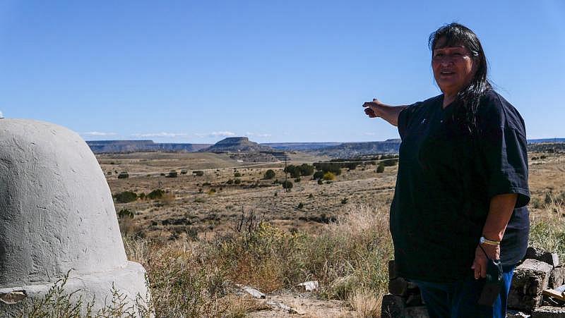 Arlene Juanico, 66, gestures toward Squirrel Mountain, the location of the Jackpile Mine, from the hill behind her childhood home in the village of Paguate, 60 miles west of Albuquerque. Photo: Eli Cahan.