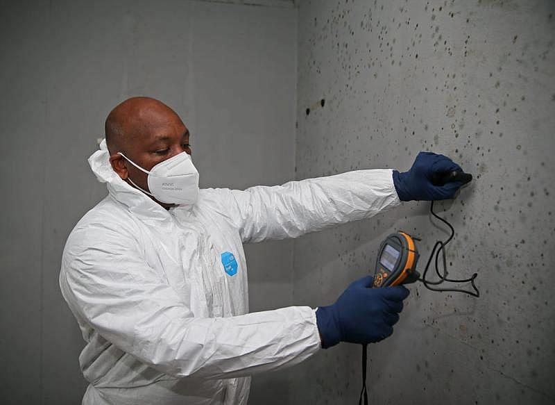 Kelly Jackson, owner and president of AJ Development Group takes a reading of the moisture level in a house where mold has been growing at 5445 N. 41st Street in Milwaukee on May 25, 2022. Smoke, mold, mildew, cockroaches and rodents are asthma triggers. ANGELA PETERSON / MILWAUKEE JOURNAL SENTINEL