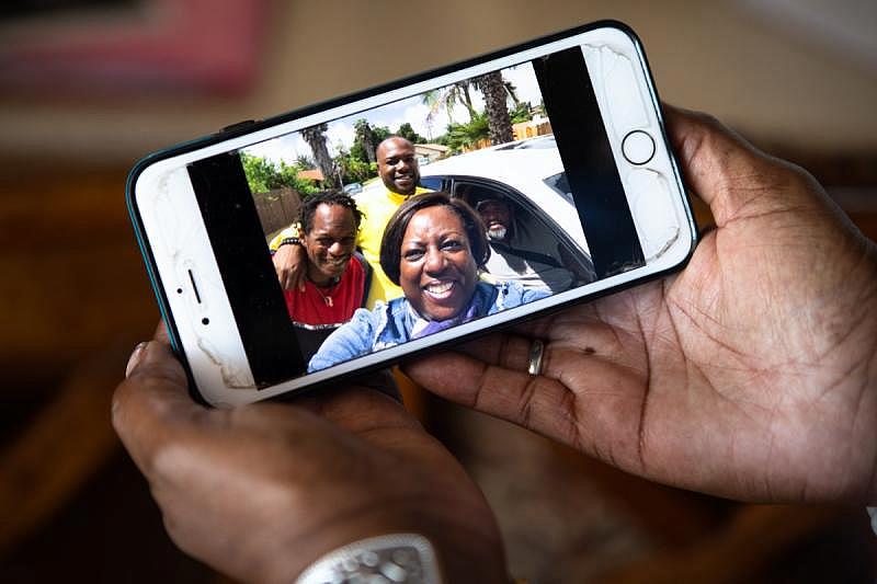 Anita Fisher shows a recent photo of her family on her cell phone at her home in Spring Valley, Aug. 16, 2022. (Zoë Meyers/inewsource)