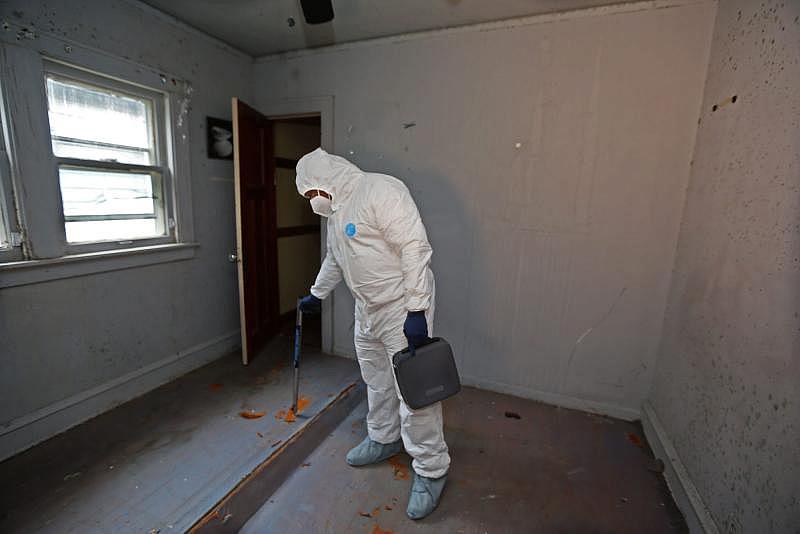 Kelly Jackson, owner and president of AJ Development Group test the moisture levels while doing an assessment for mold in a building in the 5400 block of North 41st Street. The house was damaged due to an electrical fire. Over the course of time mold began to develop inside the interior structure that was left vacant and compromised to the elements. ANGELA PETERSON / MILWAUKEE JOURNAL SENTINEL