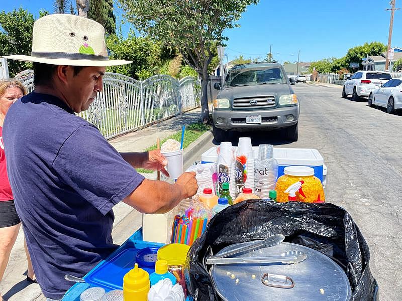 Jose Luis Millán drenches sweet walnut syrup over shaved ice. The raspado de nuez is one of his most popular flavors.