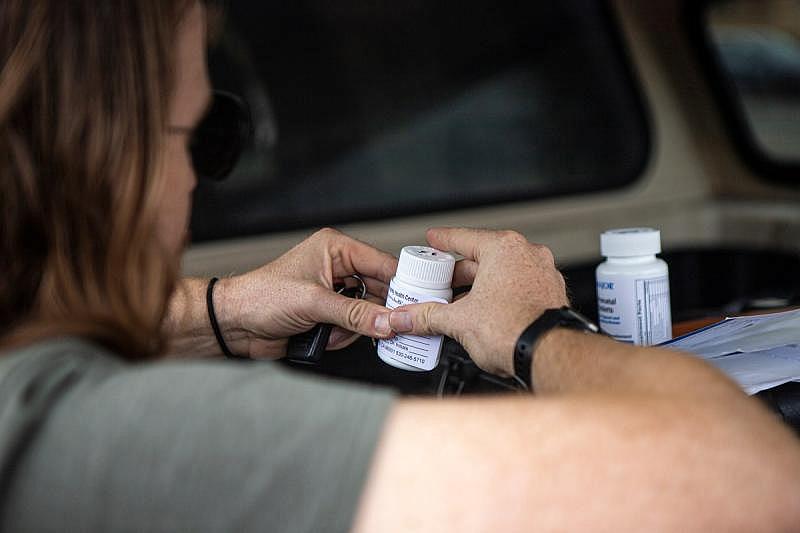 Dr. Kyle Patton reaches into the back of his truck to prescribe medication to patients he meets while driving around Redding on Sept. 19, 2022. Photo by Larry Valenzuela, CalMatters/CatchLight Local