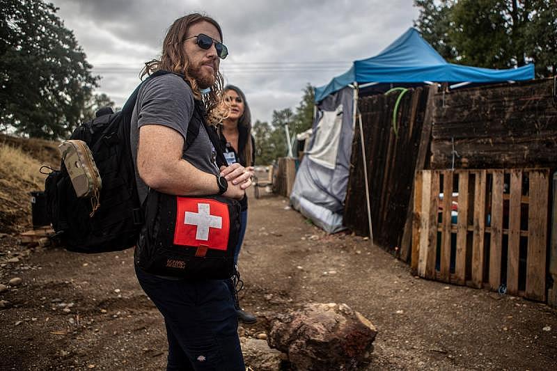 Dr. Kyle Patton waiting for his unhoused patient outside their encampment in Redding on Sept. 20, 2022. The patient reached out to Patton for medical attention. Photo by Larry Valenzuela, CalMatters/CatchLight Local