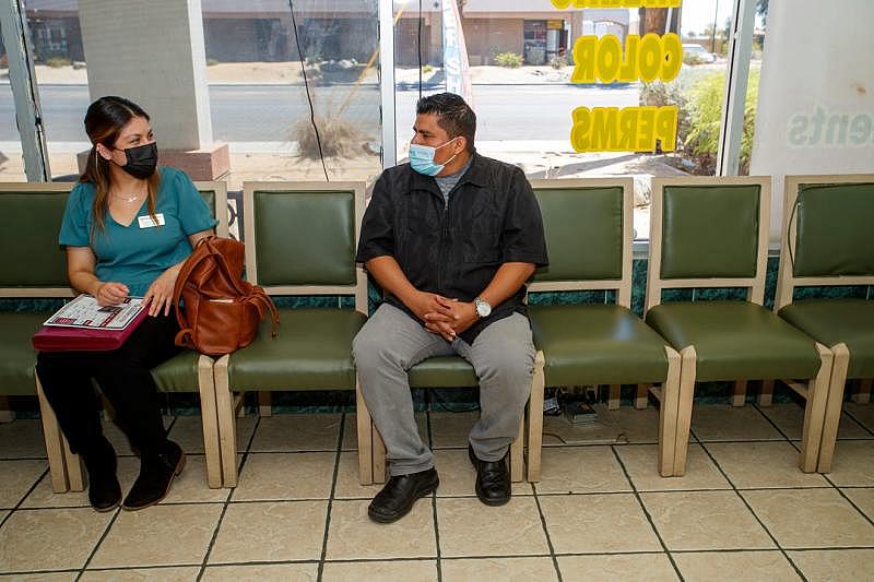 Cathedral City Senior Center outreach coordinator Laura Gutierrez, left, talks to Luna's Hair Salon owner Jose Alfredo Xicay inside his salon in Cathedral City, Calif., on Thursday, May 12, 2022. Gutierrez aims to spread the word about the senior center's new activities and draw in more seniors that might otherwise be lacking socialization and resources. Taya Gray/The Desert Sun