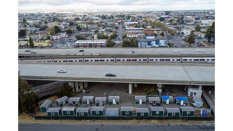 The Northgate tiny home community sits under Interstate 980 and the BART tracks in Oakland. Tiny home sites are often located on small parcels of land near freeways, away from residential neighborhoods where people have resisted them. (Shae Hammond/Bay Area News Group) 