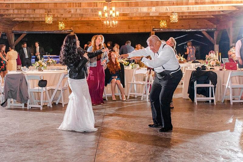 inewsource investigative reporter Jennifer Bowman, left, dances with her stepfather Harvey “Mac” McDonald at her 2019 wedding in North Carolina. (Courtesy of Stephanie Parshall Photography)