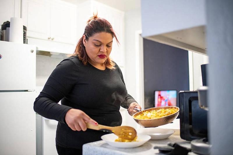 Jasmine Cuevas cooks dinner for her four children at their home in East Palo Alto on March 30, 2022. (Beth LaBerge/KQED)
