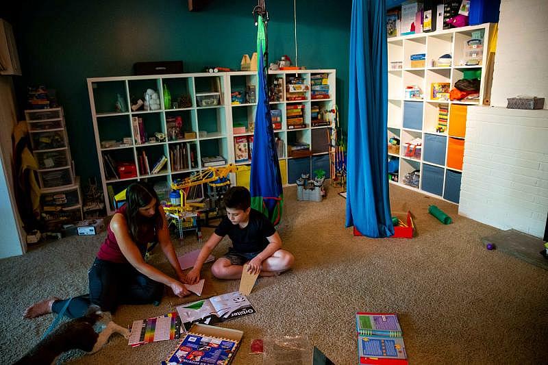 Cassie and Kai Atallah work to construct paper airplanes during a homeschool lesson at their home in Holland. Kai, who was diagnosed with autism, has been homeschooled for more than two years after experiencing the negative effects of restraint and seclusion while in school. CODY SCANLAN/HOLLAND SENTINEL