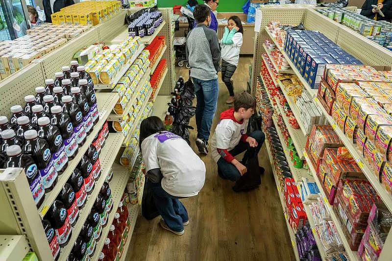 Sanger ISD students fill bags of groceries alongside their parents and school staff at the Linda Tutt grocery store in March to hand out to needy families. The store was opened more than a year ago with the help of grant money after the citys only grocery store was closed.  Mark Mulligan, Houston Chronicle / Staff photographer