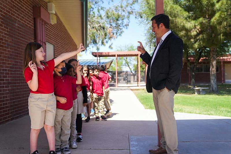 Ashlynn Shoemaker, de 6 años, saluda a Tony Alcala, director de la Escuela Primaria de Galveston, mientras los alumnos de kindergarten regresa a clases después del recreo en la Escuela Primaria de Galveston en Chandler, Arizona, el 6 de abril de 2022. ANTRANIK TAVITIAN/THE REPUBLIC