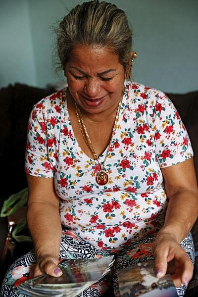 Maria Fuentes shows reporters photos of her husband in her home in the Communities at Southwood in Richmond, Va on March 9, 2008. Fuentes lost her husband to Covid-19 on July 28, 2020. EVA RUSSO/TIMES-DISPATCH  Eva Russo